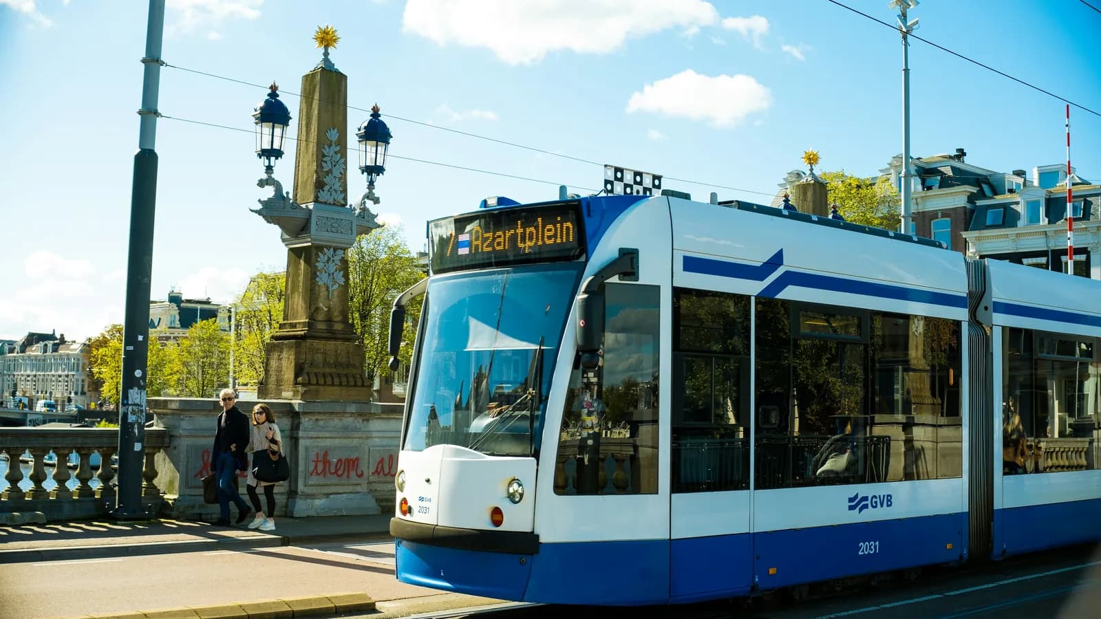 Blau-weiße Straßenbahn der GVB auf einer Brücke in Amsterdam