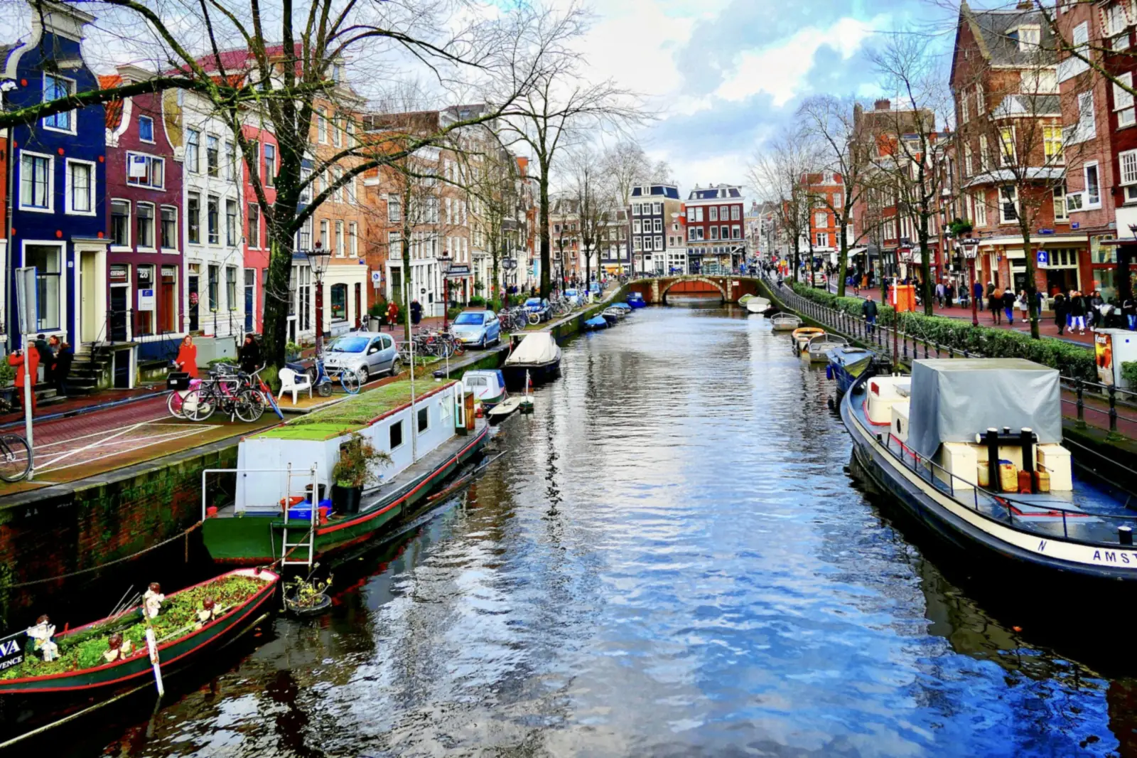 Canal d'Amsterdam avec des péniches, des vélos et des maisons colorées