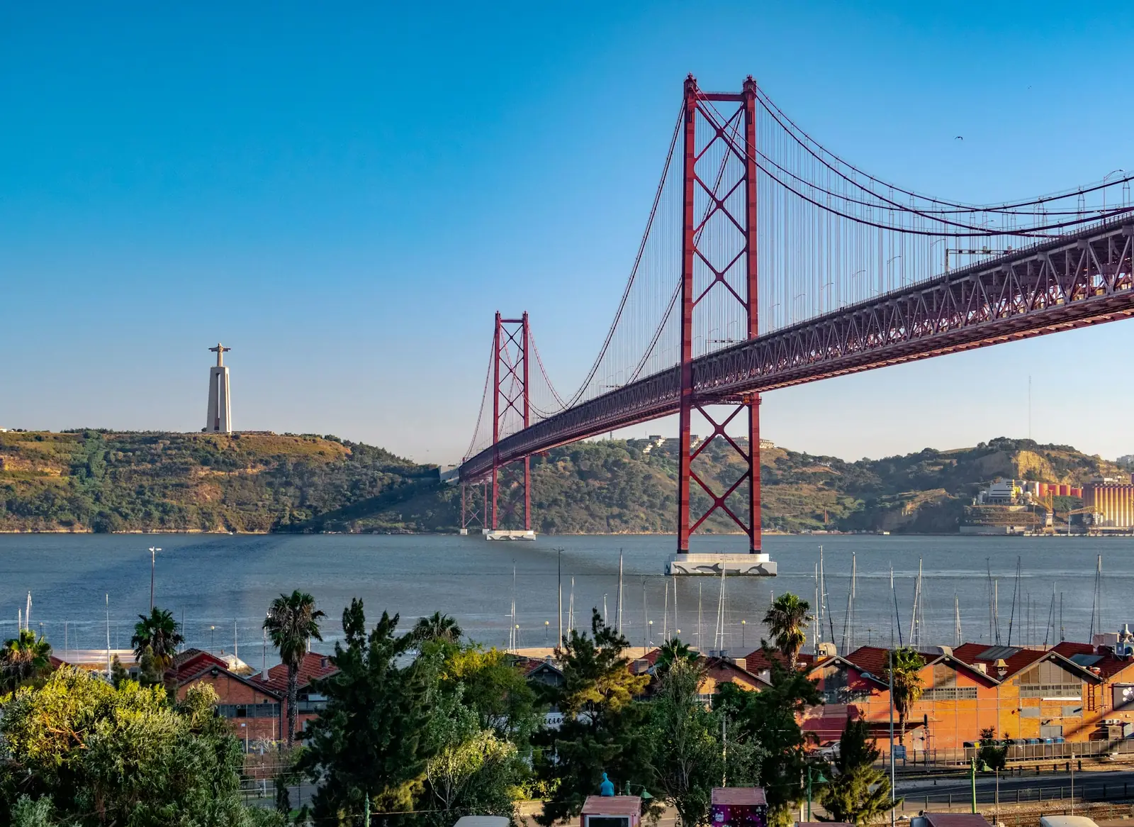 Puente 25 de Abril sobre el río Tajo con la estatua de Cristo Rey en la otra orilla